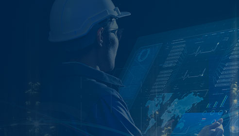Image of a man wearing a hard hat looking at a monitor with lots of data on it. There is a dark blue overlay on top of the image