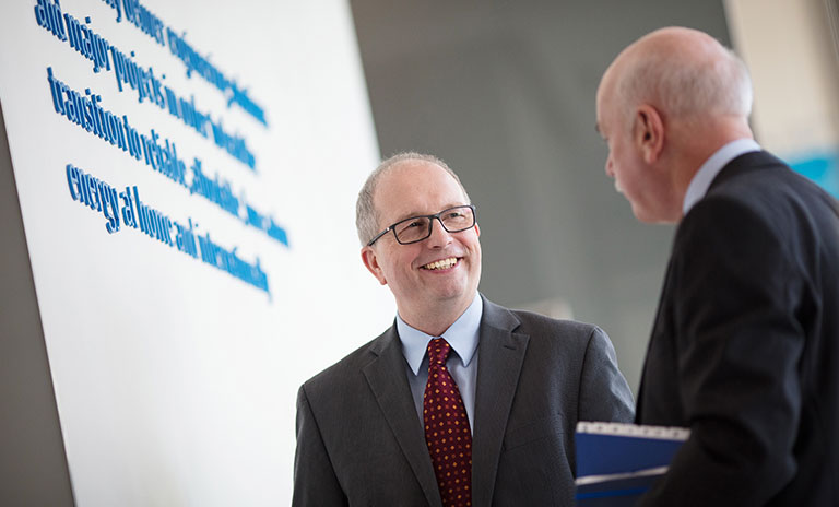 Photograph taken from below of two men having a conversation