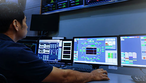 Photograph of many monitors showing charts and data