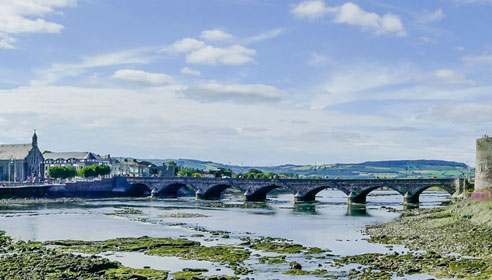 Photograph of a stone bridge over a low river