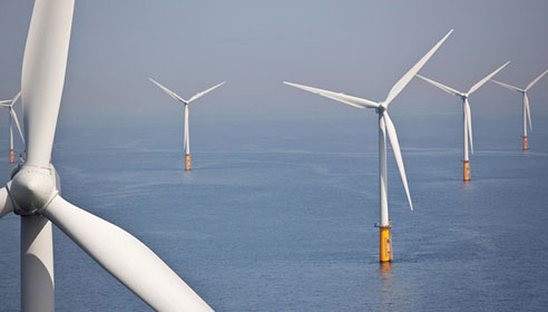 Photograph of an offshore wind farm showing wind turbines in the sea