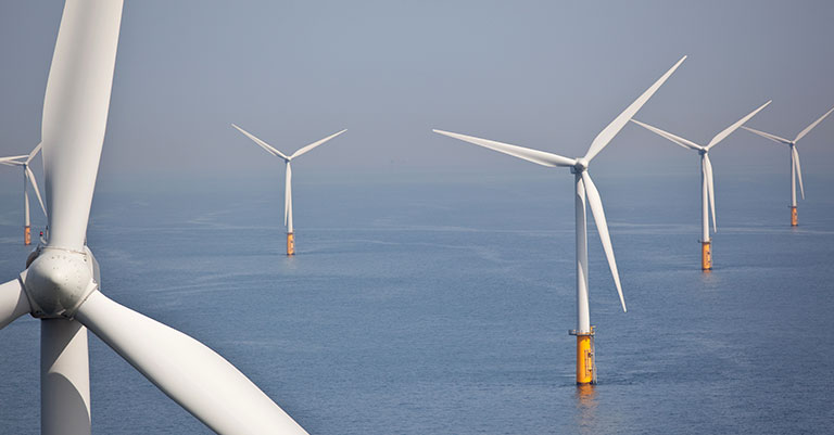 Photograph of an offshore wind farm showing wind turbines in the sea