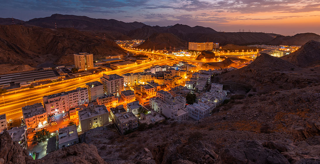 Photograph of a build up area among some mountains taken at night