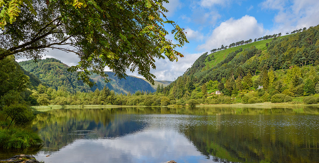 Photograph of a large lake surrounded by green hills