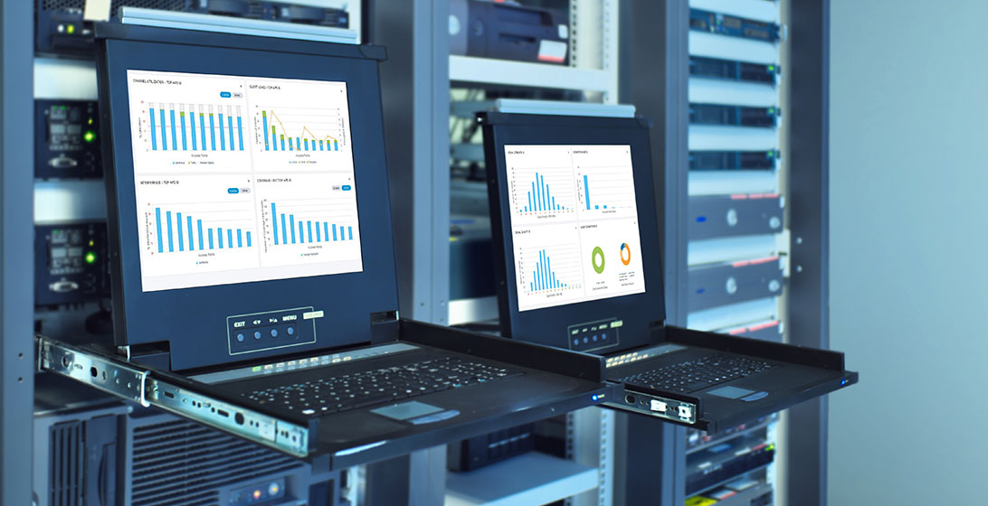 Photograph of two laptops displaying graphs on the screens